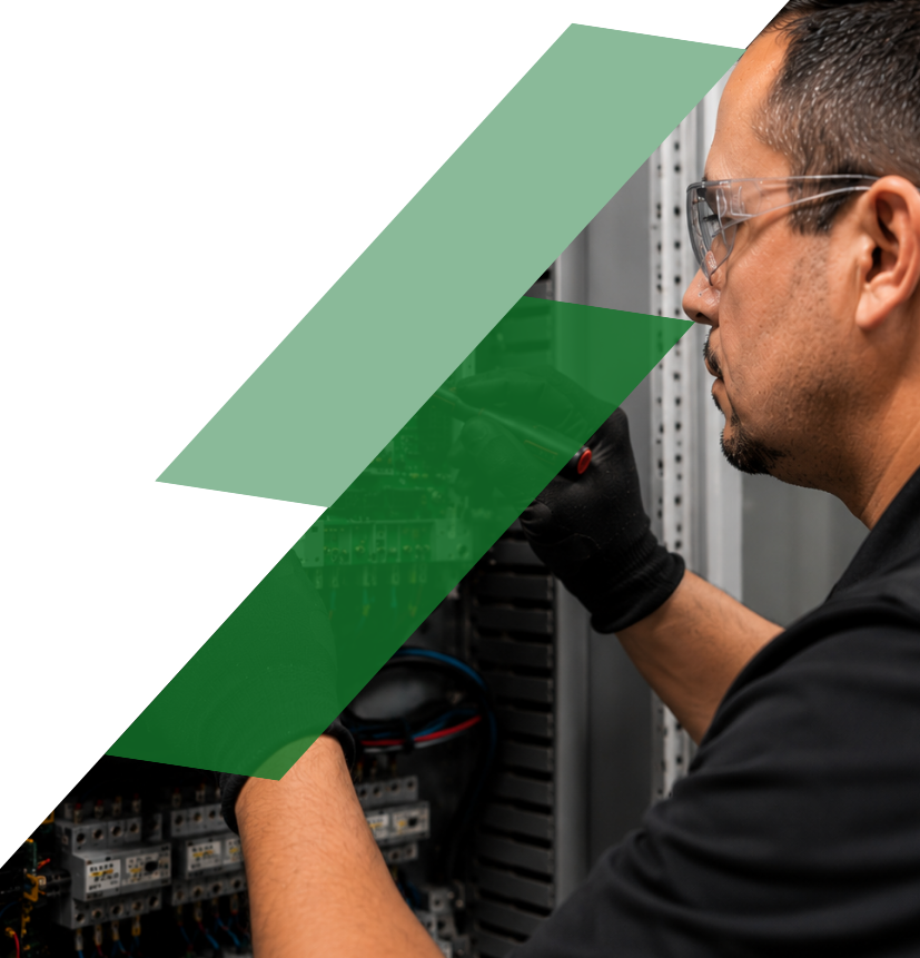 Technician diagnosing and repairing a Danfoss industrial drive inside an electrical control panel.